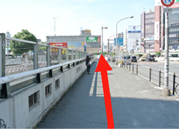 Go down to the ground level and cross the overpass over the JR Line.